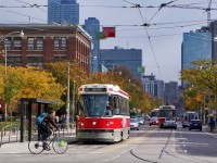 A 506 service streetcar heading west for High Park loop waits for the light to cross Spadina ave, on College St. We are in Chinatown, near Kensington Market in downtown Toronto.