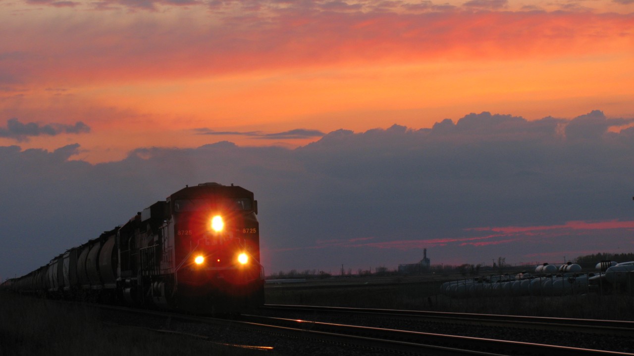 Eastbound freight rolls into Winnipeg with a beautiful prairie sunset as a backdrop.