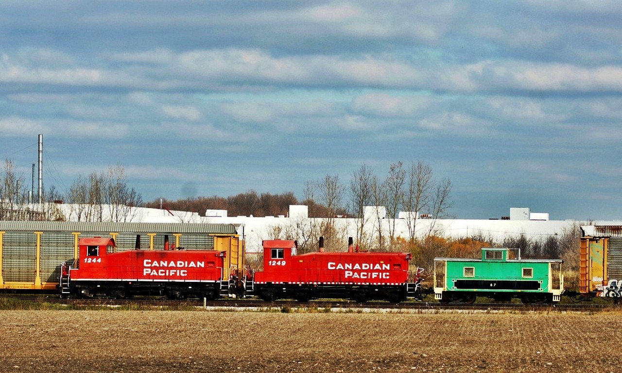 OSR 1244 and 1249, ex CP SW1200's with the van in tow are switching the CAMI Automotive plant in Ingersoll Ontario