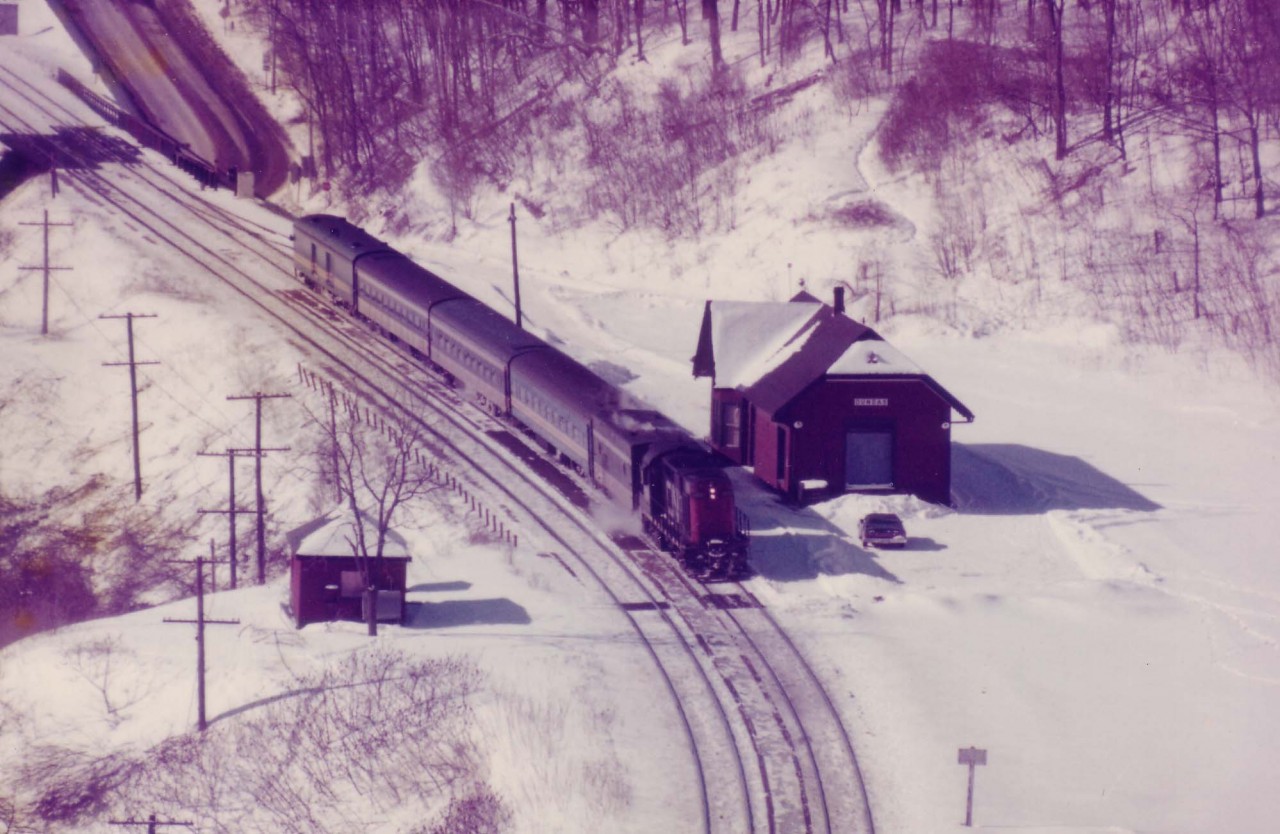 On a bright but cold sunny day CN 3105 with 4 cars & a steam jenny pulls away eastbound from the old Dundas station after its' scheduled 10:27 stop.  Station suffered a stove fire in 1986 and was demolished the following year.