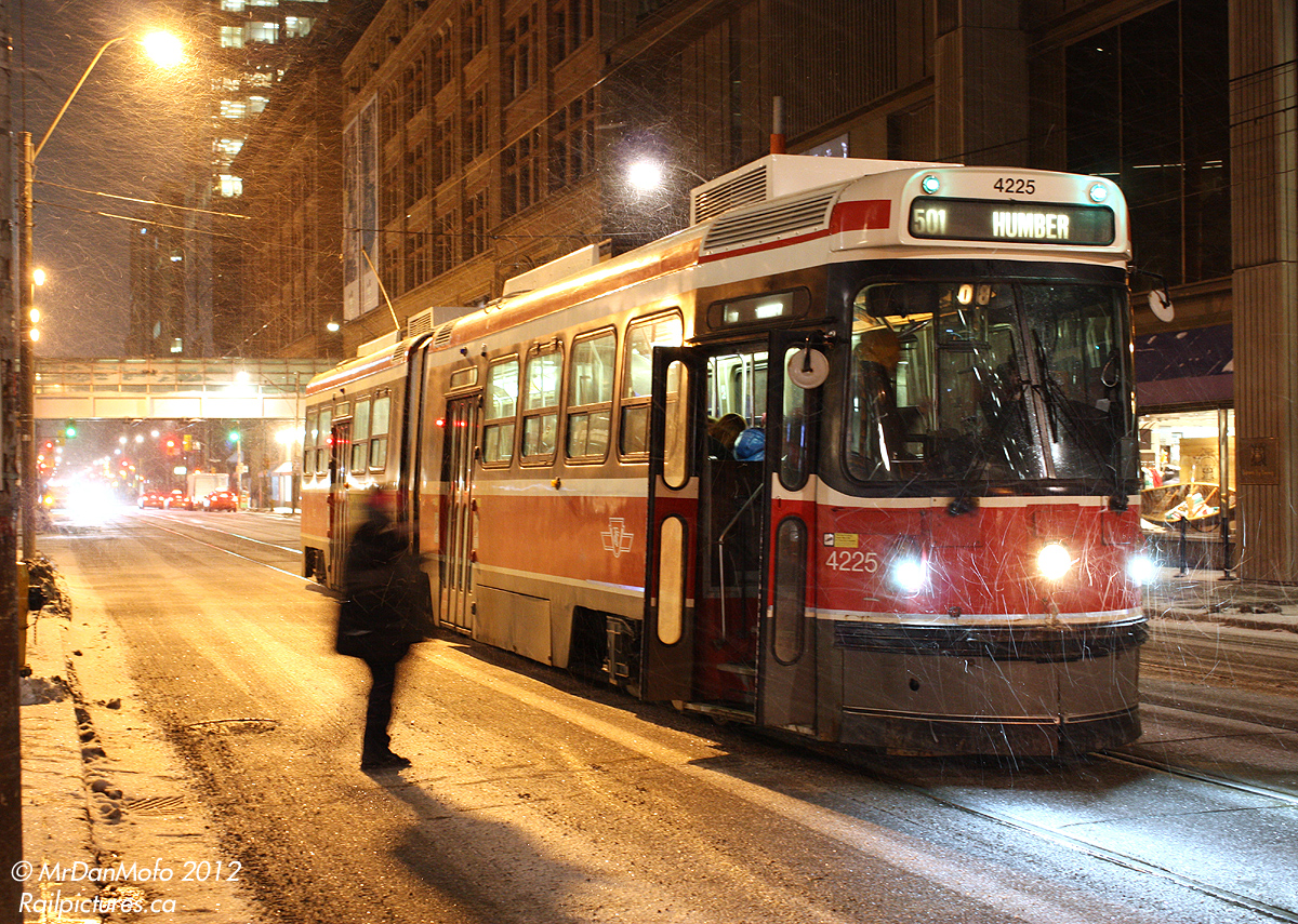 It's a cold and snowy night as a 501 car takes on passengers heading west on Queen Street, with a backdrop of the Hudson's Bay Company's decades-old flagship Toronto store at 9:30pm.