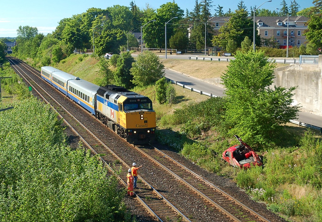 VIA 671 passing by a wrecked pickup truck which has come off of the bridge due to high speed and alcohol consumption