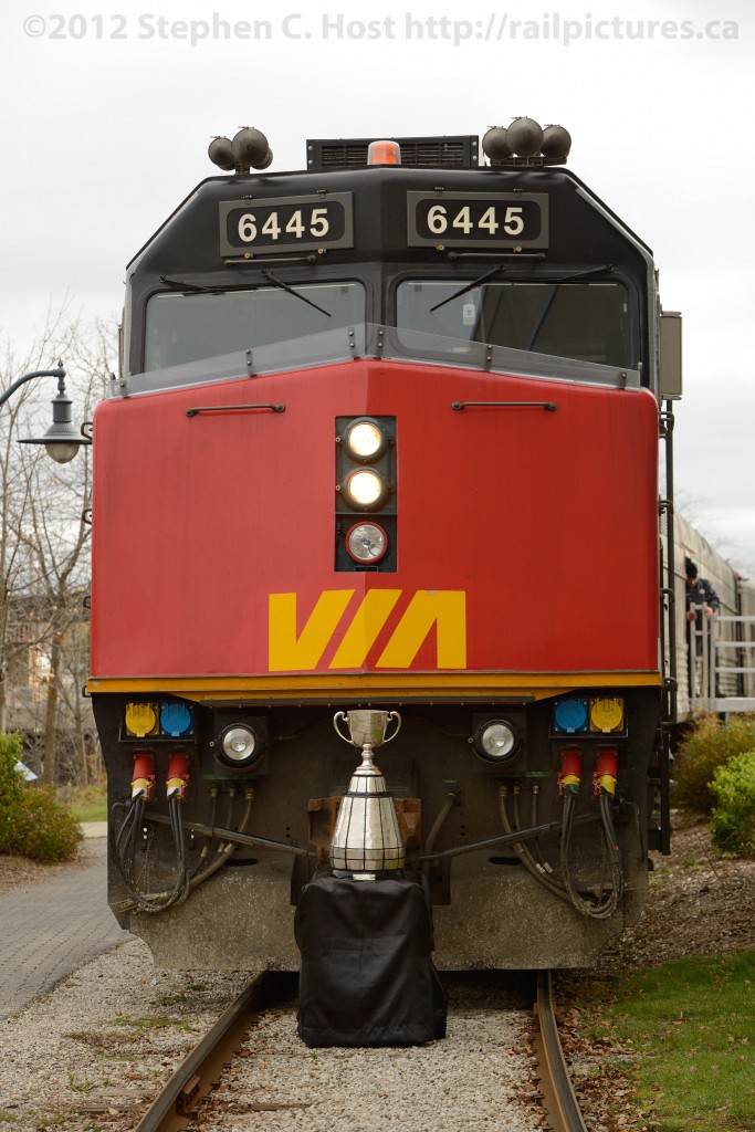 Grey Cup: The Grey Cup train is parked at Guelph, Ontario during its 100th anniversary train tour of Canada. The cup itself is dwarfed by the VIA F40PH 6445 as they are posed together for a couple of photographers.
