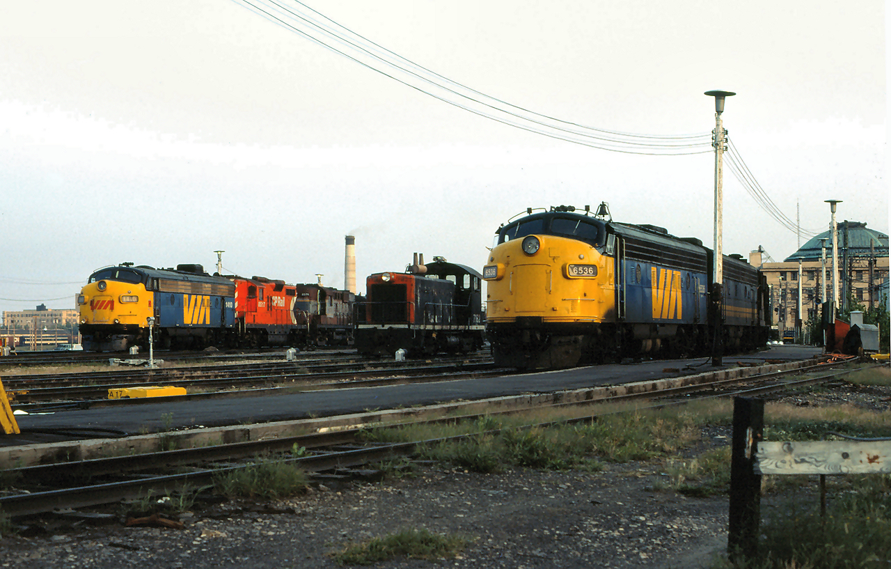 VIA #2 The Canadian led by VIA 1410 and VIA #4 The Super Continental led by 6536, bracket CN 7162 as they make their station stop at Winnipeg in 1981.