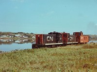 A couple of CN's vintage 70 tonners are seen here drifting westbound past St. Peter's Bay thru the idyllic countryside. CN #30 and #40 both retired after CN abandoned the Isle in the early '80s; the #30 is on isplay at Delson, QC. This train is returning to Charlottetown after taking a few cars out to Souris for the potato harvest.