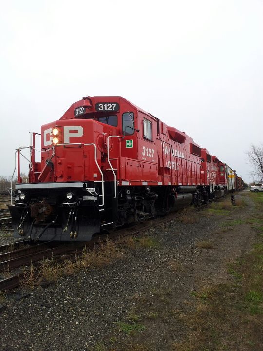 Fresh from the paint shops, 3127 and her sister pull this CWR train into Havelock, Ontario.
