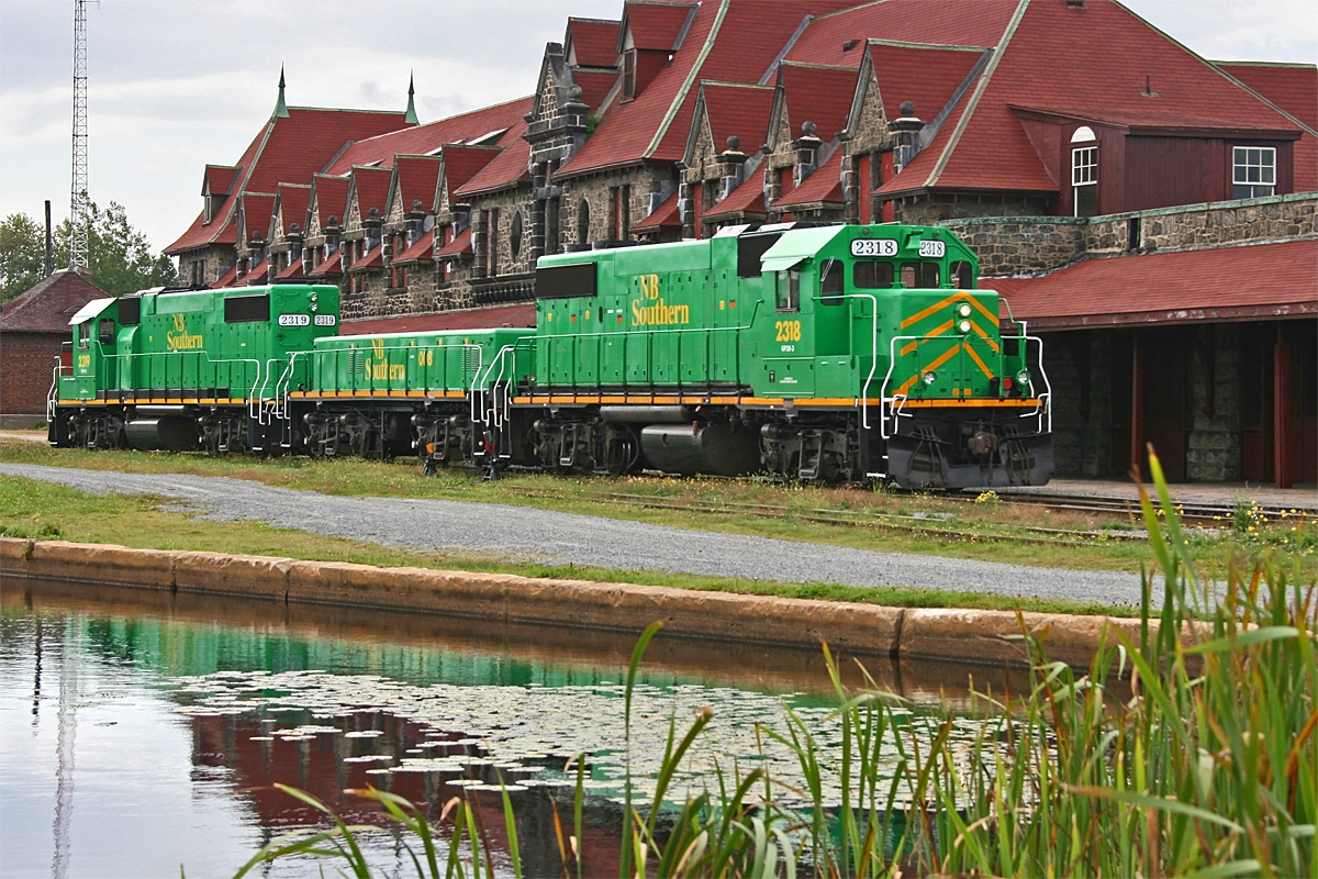 After dropping a cut of cars in the yard behind the impressive McAdam Station the power for 908 pulls ahead to rejoin their train on the main on the far side of the station, where they will wait an hour or so for trackwork up ahead to be completed before continuing on their journey from Vanceboro ME to St. John NB under the control of a new crew. Engineer Gilles and Conductor Chris spent the better part of that hour chatting it up with Wayne in the cab of 2318 while I wandered around trying to figure out just where in the heck he had disappeared to!