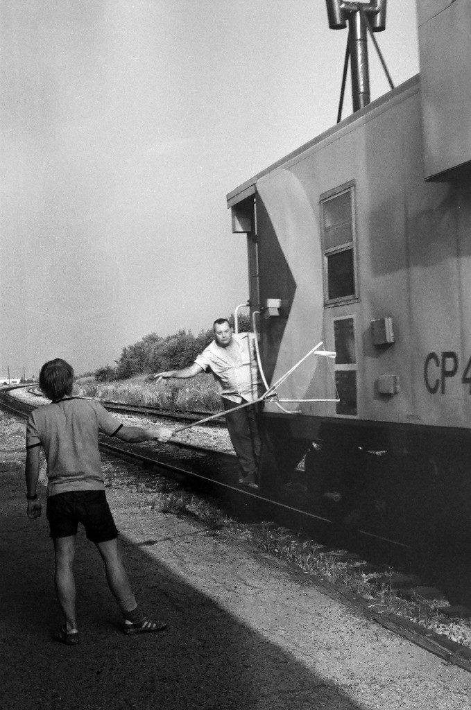 The Conductor on CP Rail train #955 (CP Rail 8600 North) prepares to take train orders on the fly at Bolton, Ontario. August 1978 negative by S. Danko.