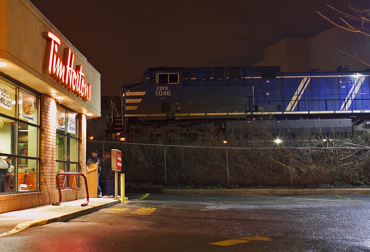 Coffee break: After waiting at Mile 1 on the Windsor sub for the Holiday train to clear, the crew of CP 540 has made it just a little closer to their crew change at Quebec street yard. A broken switch stand at the west end of the yard meant that they had to wait for well over an hour while maintenance crews repaired the switch, just shy of the Begin/End CTC Sign London (a little more than a mile from the crew change point). I don't know if they actually did go for some Timmies, but it's probably not a bad place to have to wait; I wonder if they have ever thought of adding a "rail-through" window to the store? Power was CEFX 1046-CP 8750-8200-8207.