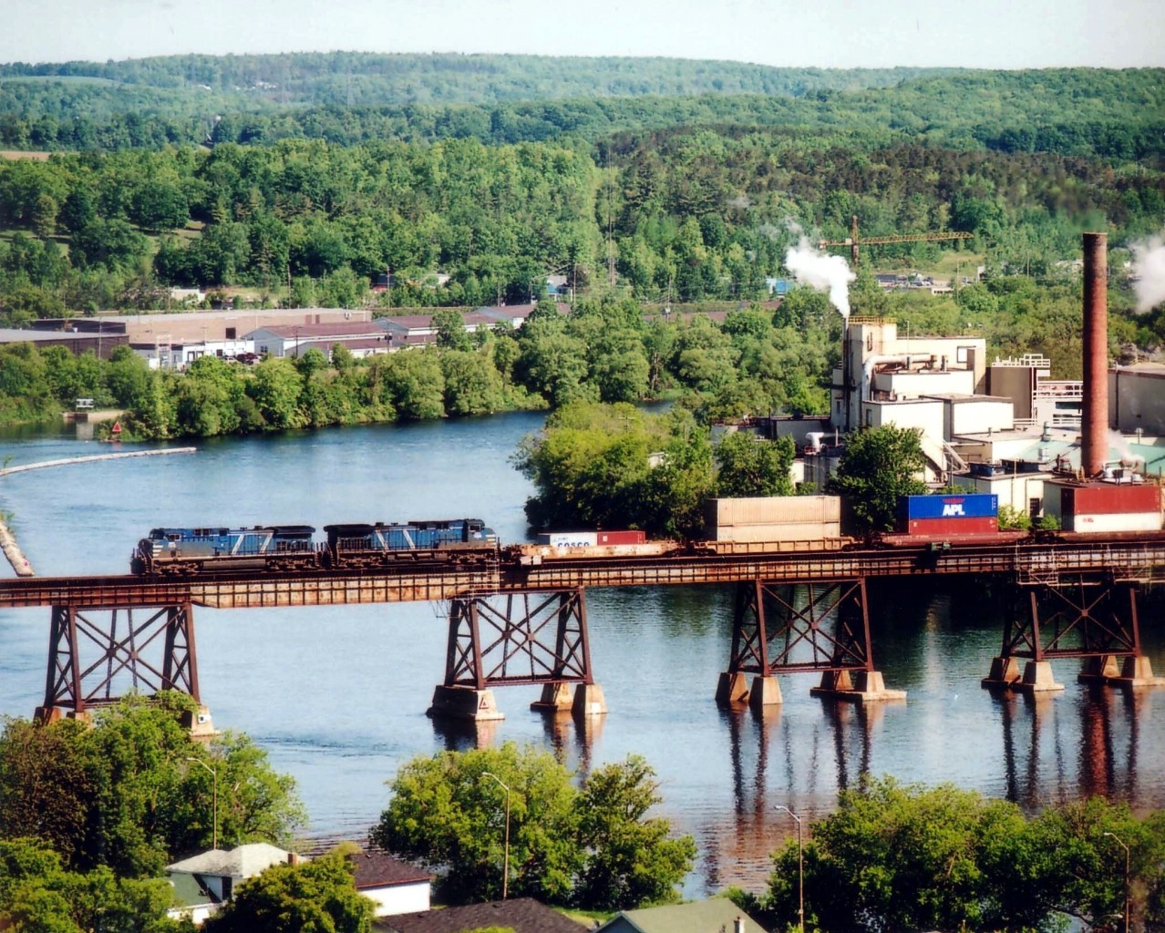 The view at the big CP bridge over the Trent River in Trenton, Ontario is well known, but the even broader view from Mount Pelion is not.  Here is a 'panoramic' shot of a matched pair of long-term lease CEFX AC4400CW units  westbound over the trestle with general freight in tow.