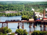 The view at the big CP bridge over the Trent River in Trenton, Ontario is well known, but the even broader view from Mount Pelion is not.  Here is a 'panoramic' shot of a matched pair of long-term lease CEFX AC4400CW units  westbound over the trestle with  stacks at the head end and general freight in tow.