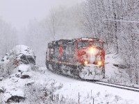 <b>Winter Wonderland:</b> CN 314 eases around the curve at Rosseau Road in between some rock cuts.