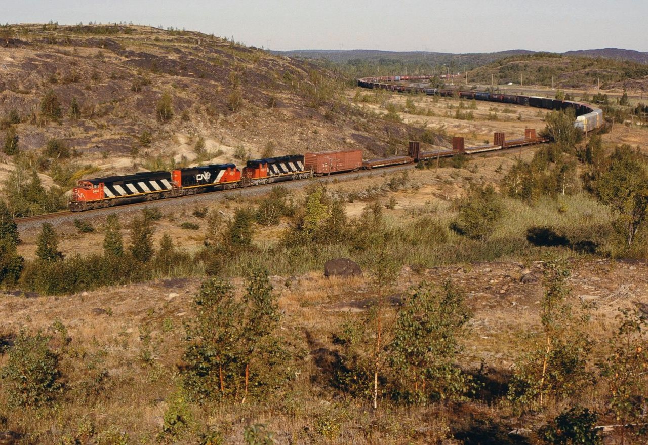 CN 5404 leading the the #336 has just crossed the CP diamond and is about to head south on the Bala Sub at Coniston, ONT.   9/17/2002

If you notice, the cab of the third unit was gotten an oil bath from the second unit with a massive oil leak...