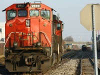 CN 2510 and 2566 bask in the afternoon sun. In the backround, Via 900 is approching the east end of London Yard, where it will reverse toward 6443, which is parked in the yard after hitting a crossing and pushing in the plow. 900 would continue the train to Mimico minus the passengers.