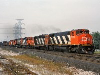 CN 3528, 4417, 4100, 3527 and a pair of SW1200RS' lead an eastbound freight through the plant at Burlington West.
