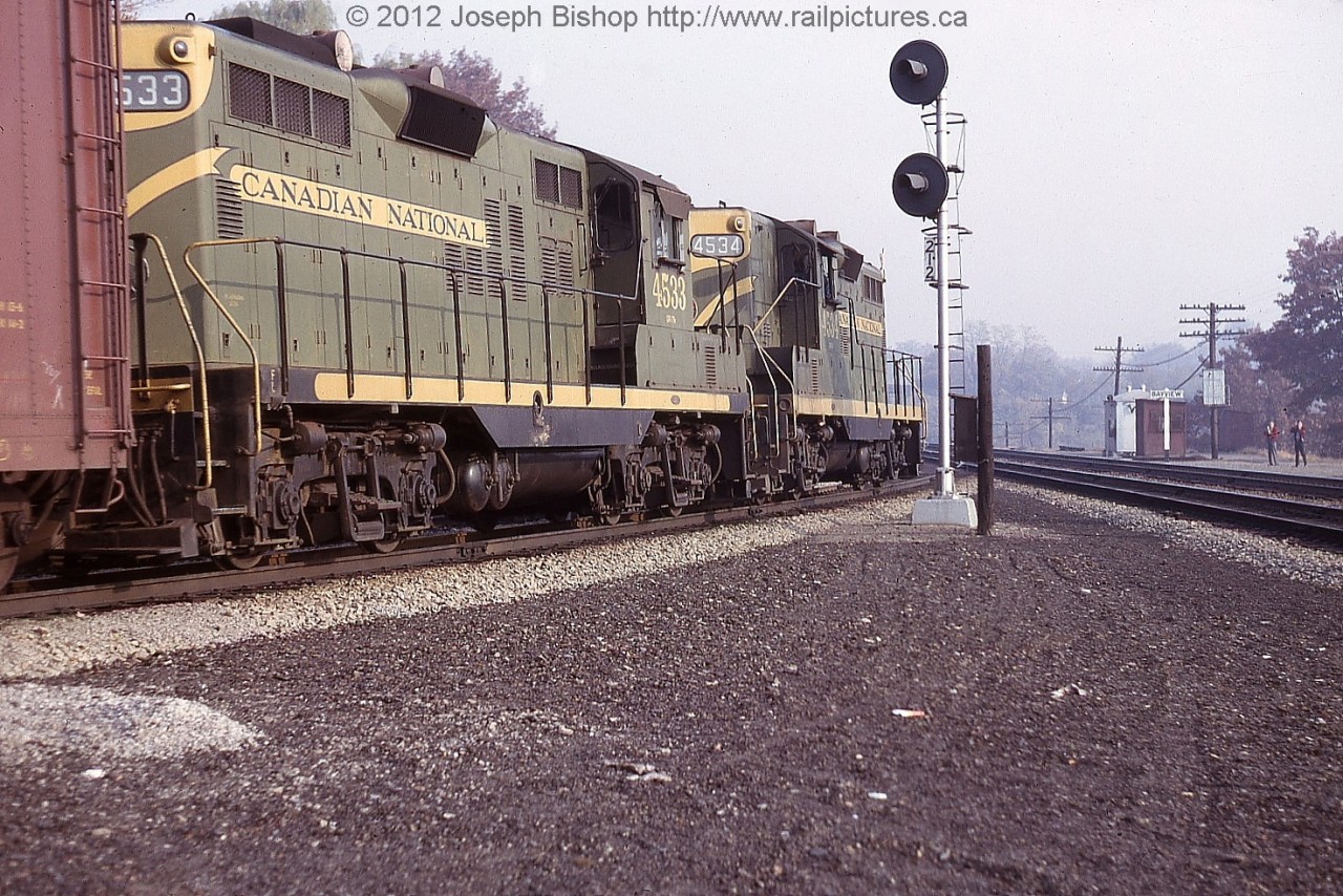 CN 4534 and CN 4533 round the bend through Bayview Junction.  They are about to exit the Dundas Subdivision and head towards Aldershot.  On the right of the photo is a couple of young railfans...perhaps they could Mr. Adeney and Mr. Mooney?

This photo is from my Great Grandfather Charles Bishop's collection.