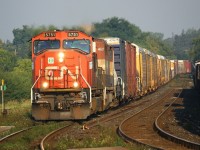 The newly painted handrails on CN 5751 stand out in the early morning sun. Accompanied by BCR 4621, 5751 slows down for the 35 M.P.H curve past the platform at the Brantford station.  
