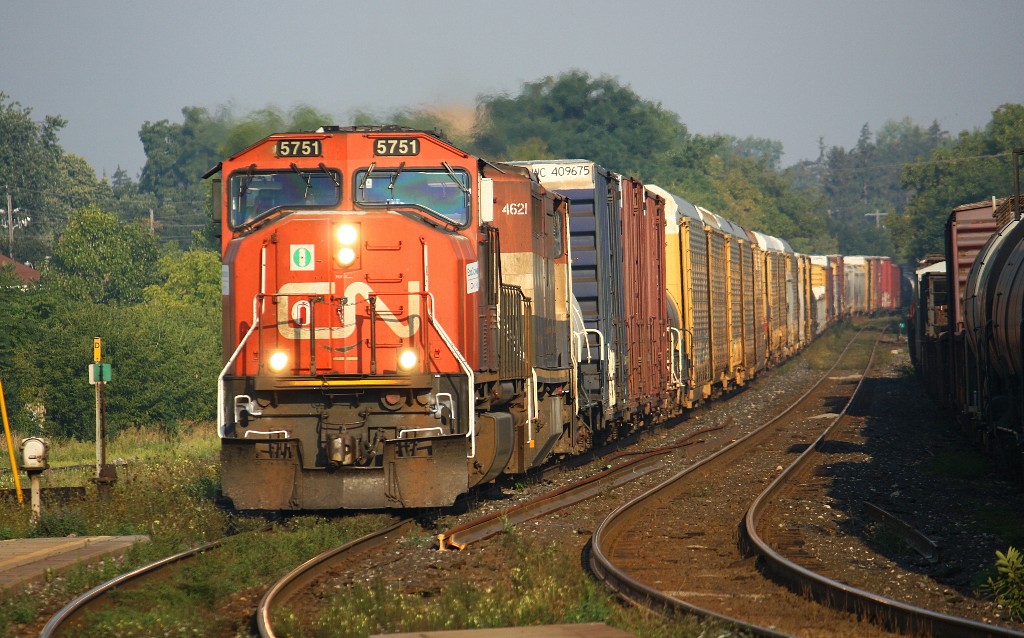The newly painted handrails on CN 5751 stand out in the early morning sun. Accompanied by BCR 4621, 5751 slows down for the 35 M.P.H curve past the platform at the Brantford station.