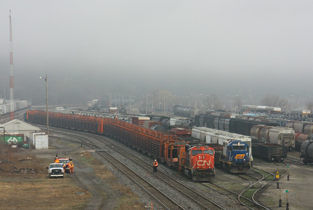 The CN railtrain rests at Hamilton as the Railink crew work around them.