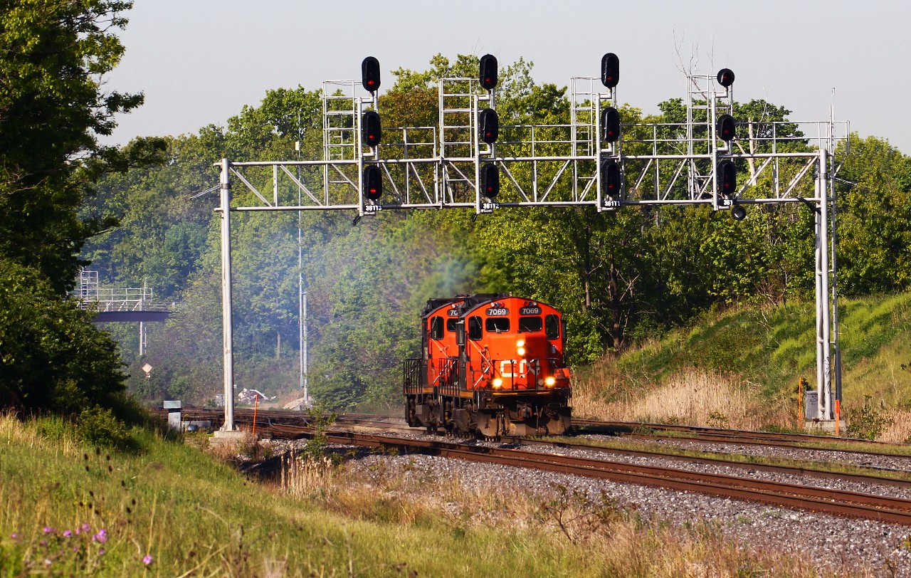 Laying down enough smoke to make any EPA inspector curious, CN 7069 and 7068 clear their throats as the accelerate eastward through CN Snake. The engines are returning to Oakville yard after delivering an extra 570 train to SOR in Hamilton, consisting of two larger pressure vessels from Hooper Welding in Oakville and a number of idler cars.