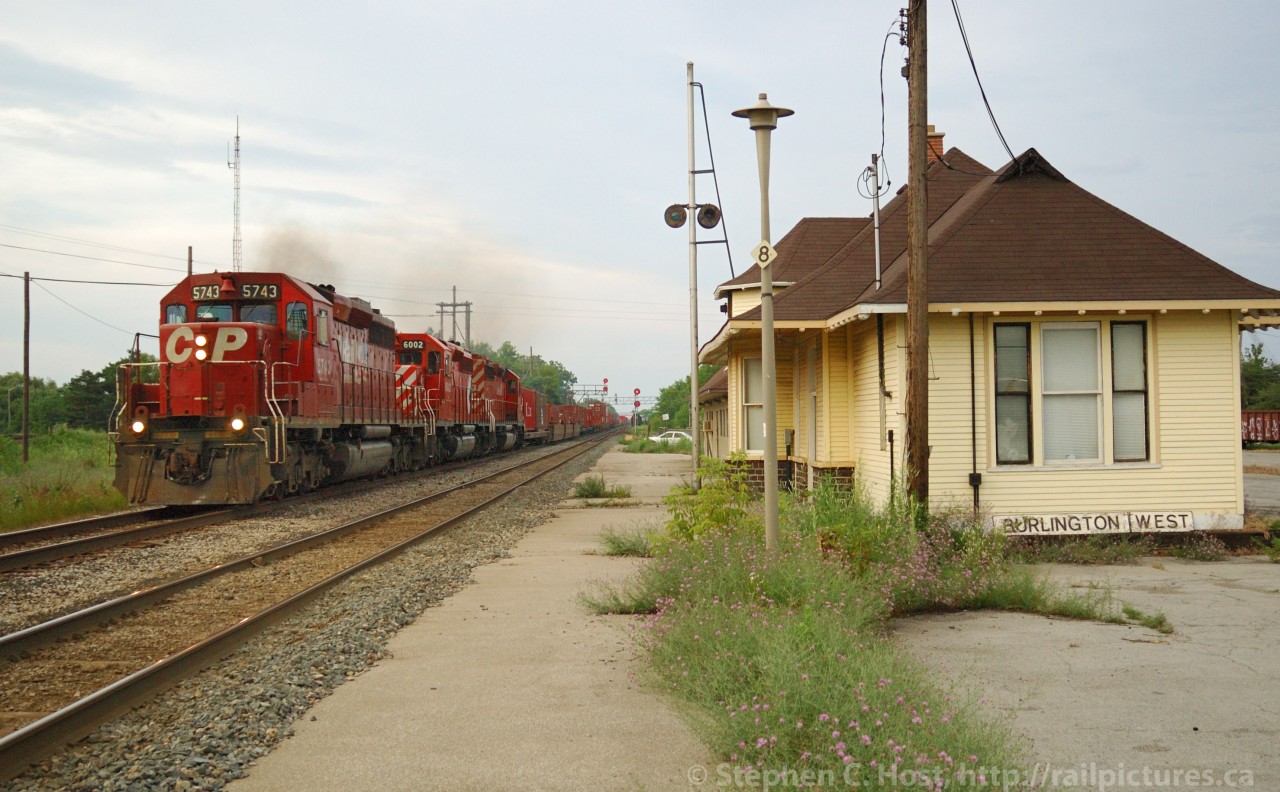Burlington West CP Train 166 (Toronto to Oak Island, New Jersey USA) is wasting no time screaming past the CN Burlington West Station with 3 sd40-2's and 100 cars of intermodal. The platform weeds are high, and most of the posts are leaning every which way, this because and the station had about one year to live in this location before being moved. CP exercised rights over the CN Oakville Sub for nearly 100 years before giving them up, having inherited running rights from the Toronto Hamilton and Buffalo Railway.