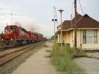 <b>Burlington West</b> CP Train 166 (Toronto to Oak Island, New Jersey USA) is wasting no time screaming past the CN Burlington West Station with 3 sd40-2's and 100 cars of intermodal. The platform weeds are high, and most of the posts are leaning every which way, this because and the station had about one year to live in this location before being moved. CP exercised rights over the CN Oakville Sub for nearly 100 years before giving them up, having inherited running rights from the Toronto Hamilton and Buffalo Railway.