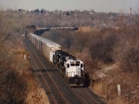 This is a follow-up to Mike Lockwoods image (i.d. 7437)from that era of great variety on CP Rail. Leading NS autoparts train #328 is CP 672, a KCS castoff later seen as CP 5417 over the system. Unfortunately this unit never wore a "CP" on the nose as 672, but just 'CP Rail" in red on the flanks. Behind the 672 are NS 3273 and 6673. View of this eastbound is at CN Iron Br., around the curve out of sight is the bridge over Welland Canal.