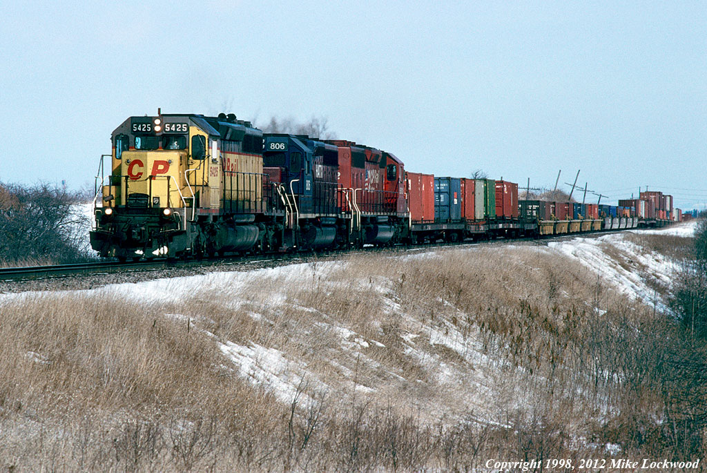 Wearing one of the fabulous temporary CP images during the St. Lawrence and Hudson era, CP 5425 leads HATX 806 and CP 5612 on 503's train west of Bowmanville. On this day, 503 didn't carry the usual head end tank cars of lime slurry from Omya at Glen Tay. A worn piece of junk, a clapped out rent-a-wreck, and a road-weary CP vetran; no wonder they called the SLH the 'Short Line to Hell'. 1255hrs.