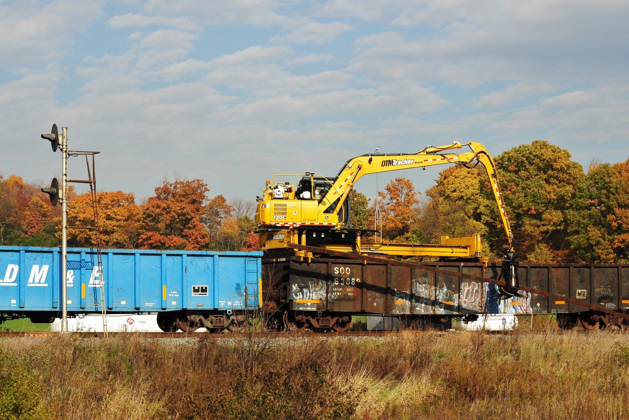 After the Cobourg Turn – CPR 3033 west - cleared 
see  click here   
the CPR M of W foreman directs the OTM Tracker (mounted on SOO 6388) to continue recovering rail, Port Hope siding mile 144 Belleville Sub. The M of W train powered by CPR Western Star #5601 07 with four gondolas from each of: DM&E, Soo Line, TH&B, and CP. October 22, 2012 image by S.Danko.