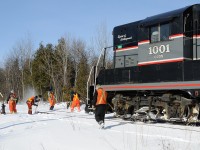 <i>Barrie Collingwood Railway chase 5 of 7. </i> Railroading in the snowbelt of southwestern Ontario is no easy task, however this crew makes it look easy as four men tackle the snowed in switch; one with a "blower", one a switch broom and the other two with shovels. This conductor (long haired man in the centre of the frame) has it good today in stark contast too other shortlines where rail crew members (engineer and conductor) are down on the ground clearing switches. Once he is able to line the switch, the engine will reverse onto the cars they just ran around in order to spot Canadian Mist. At Canadian Mist the crew will have lunch before continuing their trip back east to Utopia and a quick switch at F.S. Partners in Stayner.
