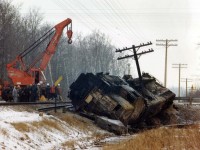 The first locomotive ever built by GMD in London after the locomotive division came into existence in 1950 was TH&B's GP 7  #71, and it met an untimely fate at Webber Rd, a few miles west of Welland on Feb. 12, 1980. A loaded semi failed to stop and broadsided the locomotive, knocking it into the ditch. Fuel spills resulted in both the truck and locomotive catching fire. The railroad crew survived but the truck driver perished.
This view is from the following morning, as a heavy crane positions itself to assist in the attempt to bring #71 back onto its feet; and later it was taken to Hamilton........and eventually the scrapper.