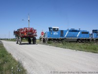 A farmer makes what would appear to be a very dangerous move at a crossing in Garnet Ontario.  In reality the train is backing away from the crossing and the farmer is not putting himself at risk at all.  This photo was taken at the SOR yard at Garnet Ontario