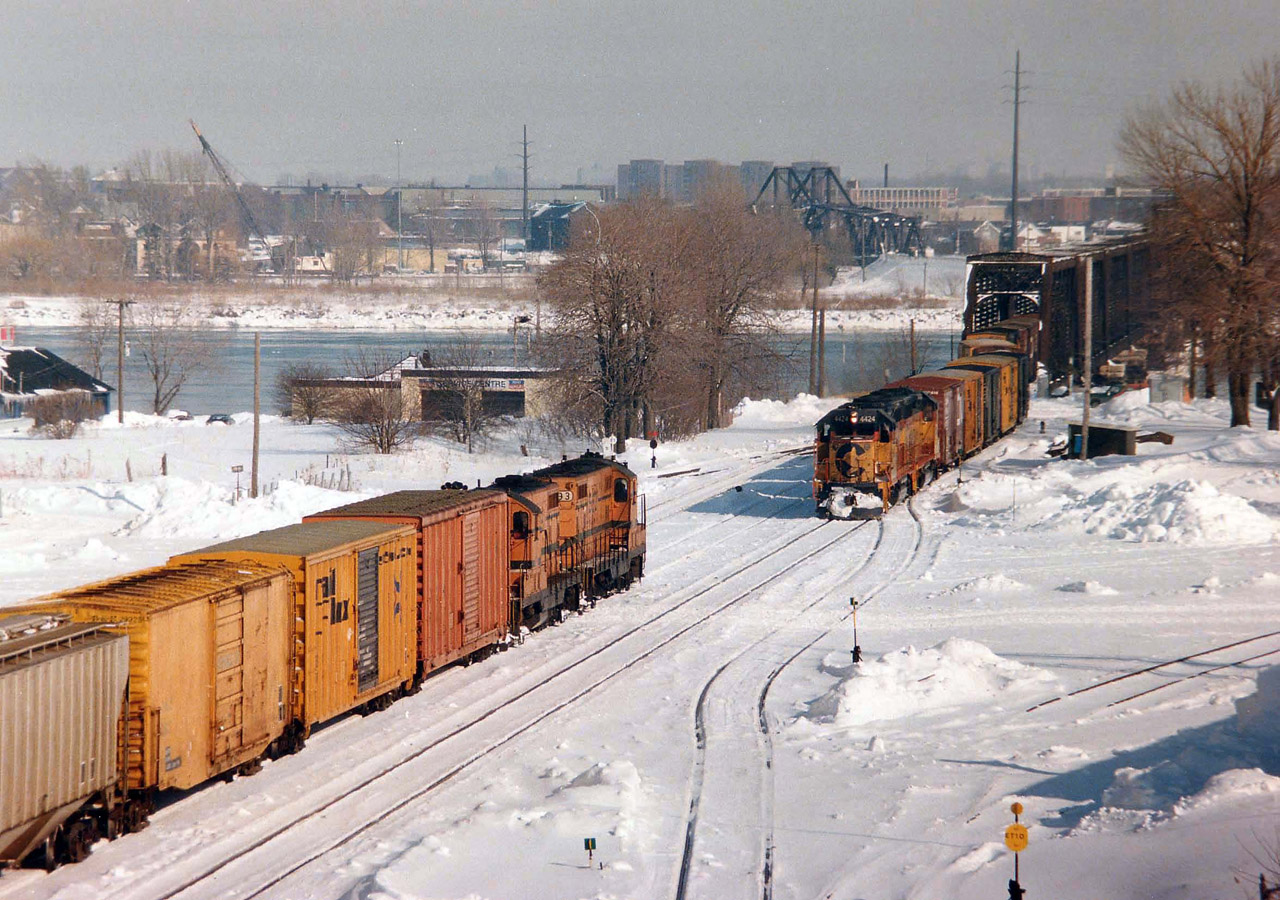 Over the International Bridge at Fort Erie comes Chessie (B&O) 4424 and 4277 with a transfer while Maine Central 593 and 591 are heading Stateside.
Fort Erie's CN used to be quite busy daily with transfer runs coming over from the USA.
Chessie, Conrail and NS....I'm guessing MEC power was available on this particular day. Anyone have proper information?
Photo taken from Central Av Bridge.
"Black Rock", over in Buffalo, can be seen over the river.