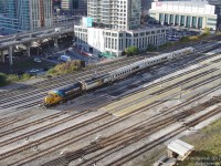 <b>15 Floors Up and Heading for the Northlands</b>. At the pinnacle of morning rush hour in Toronto, Ontario Northland's daily (except Saturday) Northlander departs Toronto's Union Station at 9:00am sharp. Negotiating the maze of tracks to the east of the trainshed over the Yonge Street viaduct, the train will make its way over to Cherry Street and head up the Bala Sub, where it will begin its journey to northern Ontario. GP38-2 "Class unit" 1800 leads today's typical consist of ex-MILW F7B HEP generator car 202, and single-level Hawker Siddeley coaches 609, 600, & 702 that are all-too-familiar with Union Station; having worked for GO Transit for decades out of Toronto.<br><br>But all good things must come to an end. Discontinued by the Ontario Liberal government at the end of September 2012, to the photographer the Northlander will always be that mis-matched oddball of a passenger train departing amid a flood of GO Trains from 15 floors up.