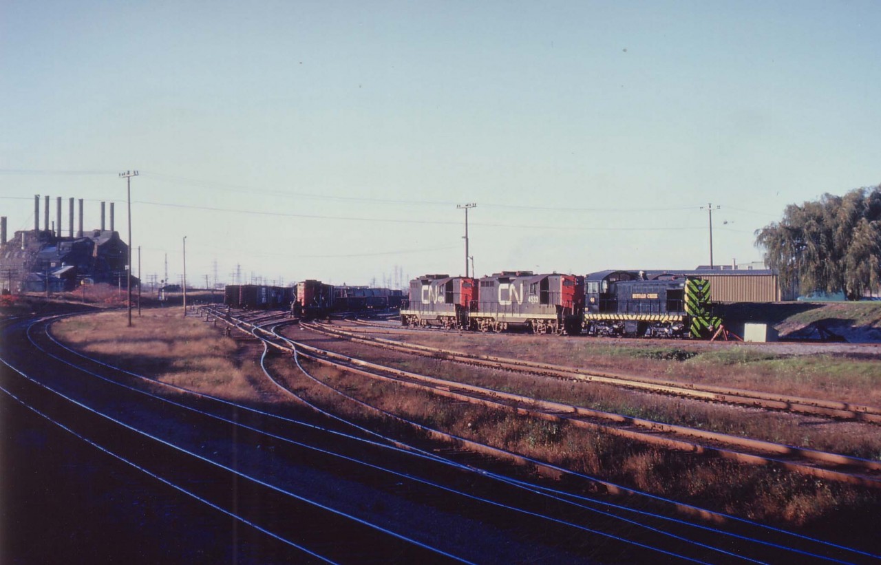 An old CN view at Niagara Falls, Ont. On the extreme left is the double track CN Grimsby sub., mile 0.6. That is about all that remains in 2012. The factory on the left, Cyanmid Chemicals, this infamous operation long razed. The CN yard has been torn up this fast few years. The shop building might still exist, but the track and the power is history.
In this very late afternoon view, the sunset minutes away, one can see on the loco track, CN 4524, CN 4533, and of all things, Buffalo Creek #44.
It eventually became Conrail #9661 in the 'big swallow-up'.