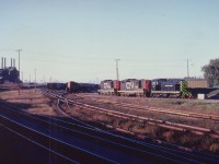 An old CN view at Niagara Falls, Ont. On the extreme left is the double track CN Grimsby sub., mile 0.6. That is about all that remains in 2012. The factory on the left, Cyanmid Chemicals, this infamous operation long razed. The CN yard has been torn up this fast few years. The shop building might still exist, but the track and the power is history.In this very late afternoon view, the sunset minutes away, one can see on the loco track, CN 4524, CN 4533, and of all things, Buffalo Creek #44.It eventually became Conrail #9661 in the 'big swallow-up'.