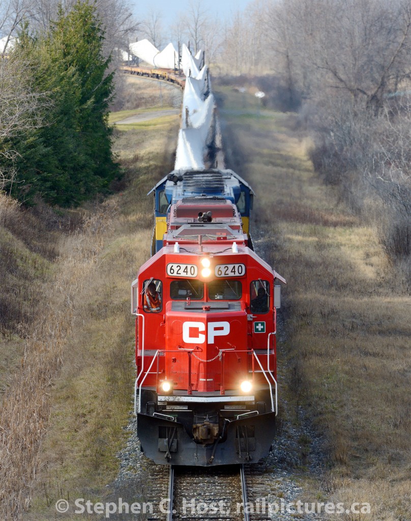 DIM-004, a train of Windmill Blades destined for unloading at Welland, Ontario is cresting the Niagara Escarpment at Vinemount, Ontario. Trailing the lead unit is ICE 6415.