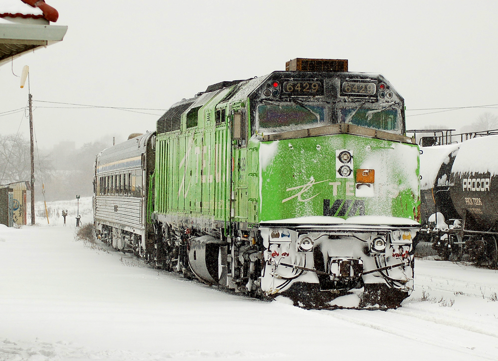 VIA #73 with Telus wrapped 6429 pushing on the rear departs Brantford about 40 minutes late during a heavy dumping of snow