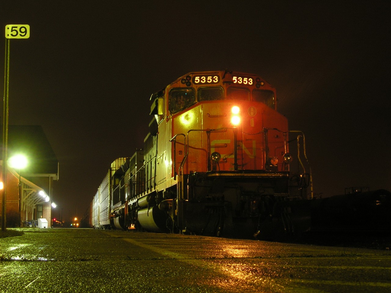 CN 5353 idles in front of the VIA Rail Station in Sarnia, Ontario, under misty skies.