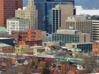 CP 246 passes by GO Train sets parked for the weekend at the downtown Hamilton GO Centre. The Hamilton subdivision dissects the Corktown neighborhood (foreground) from the downtown core. The brown Stelco Tower and the Art Deco/Gothic Revival style Pigott building along with the partially frozen bay and Niagara Escarpment add to the background. 