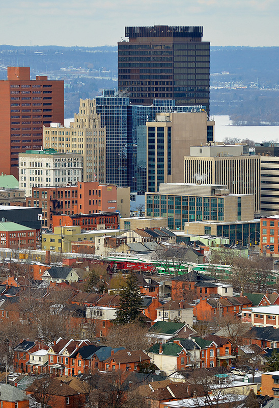 CP 246 passes by GO Train sets parked for the weekend at the downtown Hamilton GO Centre. The Hamilton subdivision dissects the Corktown neighborhood (foreground) from the downtown core. The brown Stelco Tower and the Art Deco/Gothic Revival style Pigott building along with the partially frozen bay and Niagara Escarpment add to the background.