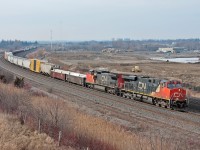 A GEVO and ex BNSF C40-8W lead a very late CN 308 through Oshawa. Just north of the tracks is the spot of GO Transit's new maintenance facility in it's beginning stages. 
