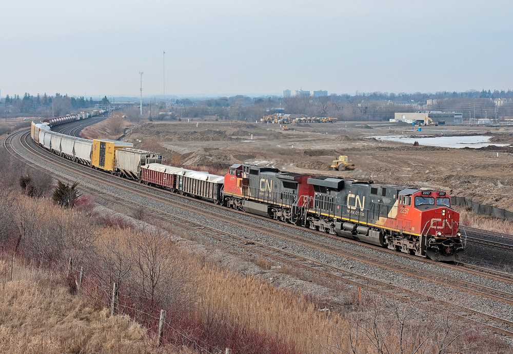 A GEVO and ex BNSF C40-8W lead a very late CN 308 through Oshawa. Just north of the tracks is the spot of GO Transit's new maintenance facility in it's beginning stages.