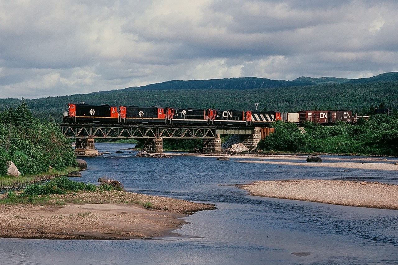 A railway that owned 51 diesel locomotives and where the daily freight trains have a 548 rail route mile run...(and is now gone...)



...today, August 2, 1982, the daily train is five hours into the 24 hour run to St. John's: Terra Transport #204 is at the Black Duck River bridge with five NF210's: TT#910 - TT#940 - TT#917 - TT#919 (CN noodle) - TT#918 (CN zebra) with eighty plus cars: a dimunitive railway? Hardly. 


(what's interesting: some distance perspective, compare the Terra Transport Port-aux-Basque to St.John's: 548 rail route miles to the Windsor Ontario to Montreal Quebec: 558 CN rail route miles.)



More Terra Transport:


  Terra Transport #232 near Clarke's Beach  


    Terra Transport #206 near Lockston  


    Terra Transport power for #204, Port-aux-Basques  


    TT #927, Port-aux-Basques  


   TT #929, Corner Brook  


sdfourty.