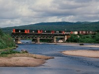 A railway that owned 51 diesel locomotives and where the daily freight trains have a 548 rail route mile run...(and is now gone...)<br><br>...today, August 2, 1982, the daily train is five hours into the 24 hour run to St. John's: Terra Transport #204 is at the Black Duck River bridge with five NF210's: TT#910 - TT#940 - TT#917 - TT#919 (CN noodle) - TT#918 (CN zebra) with eighty plus cars: a dimunitive railway? Hardly. <br><br>(what's interesting: some distance perspective, compare the Terra Transport Port-aux-Basque to St.John's: 548 rail route miles to the Windsor Ontario to Montreal Quebec: 558 CN rail route miles.)<br><br>More Terra Transport:<br><br> <a href="http://www.railpictures.ca/?attachment_id=7438"> Terra Transport #232 near Clarke's Beach </a> <br><br>   <a href="http://www.railpictures.ca/?attachment_id=6808"> Terra Transport #206 near Lockston </a> <br><br>   <a href="http://www.railpictures.ca/?attachment_id=6608"> Terra Transport power for #204, Port-aux-Basques </a> <br><br>   <a href="http://www.railpictures.ca/?attachment_id=6220"> TT #927, Port-aux-Basques </a> <br><br>  <a href="http://www.railpictures.ca/?attachment_id=6336"> TT #929, Corner Brook </a> <br><br>sdfourty.