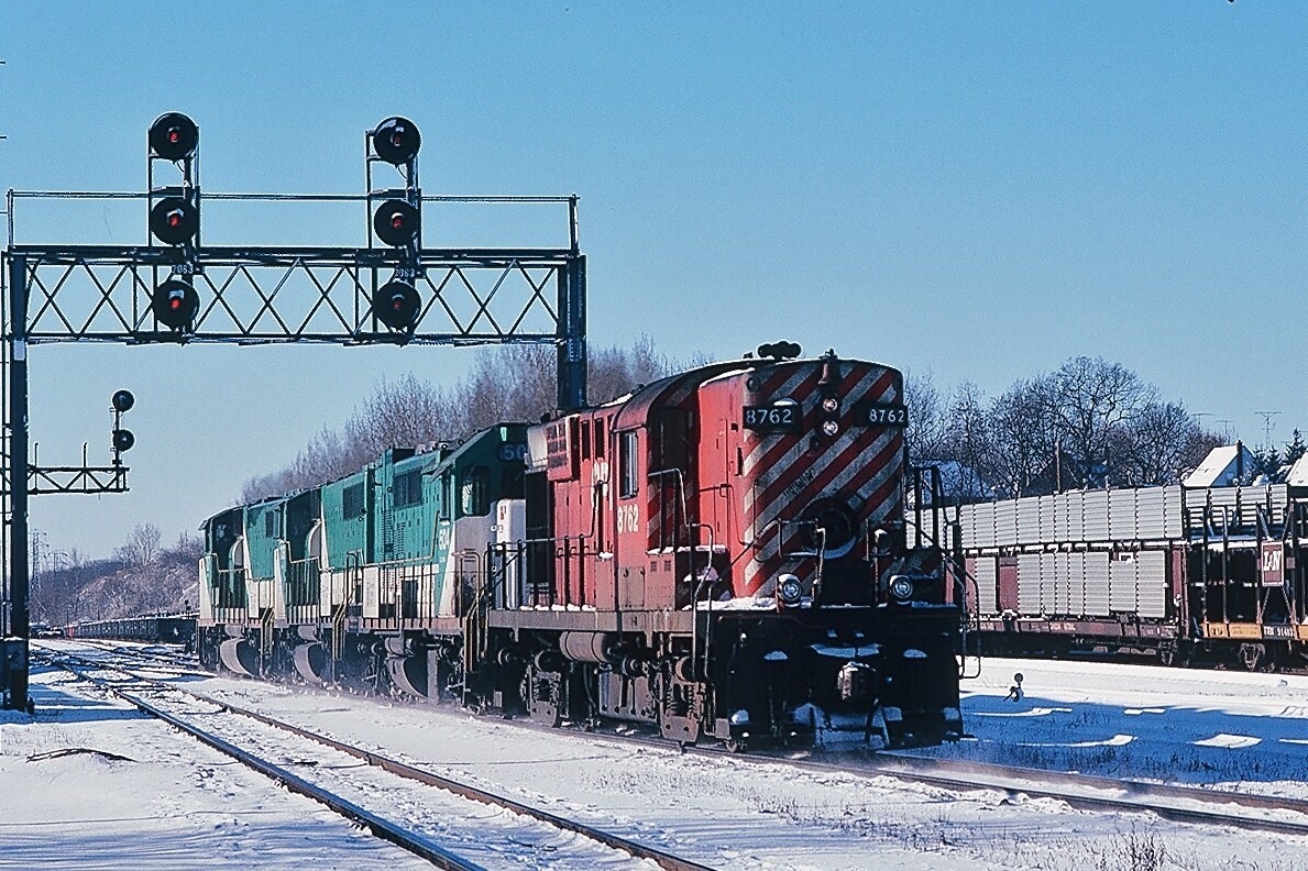 Return run - it is Sunday afternoon: GO 7xx, 7xx and 504 are on the Leaside crossover heading down to Don and onward to their owner. CP Rail RS-18 #8762 - the future #1803 - is the CP crew's return ride. December 1979 Kodachrome by S. Danko.