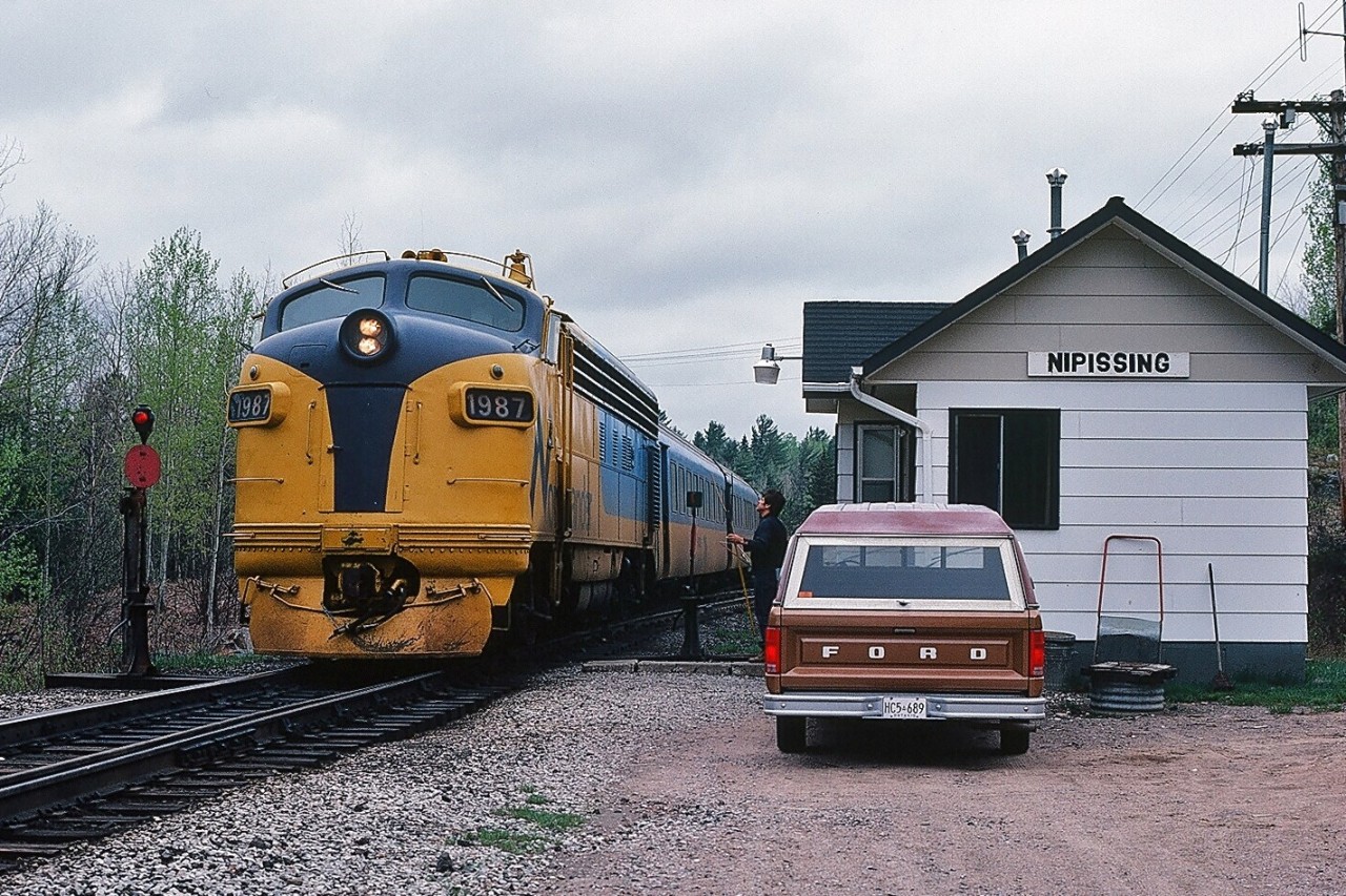 The O.N.R. Northlander with FP7m #1987 (ex #1510) is CN train #122 at CN Alderdale Subdivison mile 51.5; #122 is following instructions within CN Timetable Footnotes 1.1 and 2.23 "Nipissing - all trains may register by register ticket" and "Operating Nipissing is in charge of junction switch" - prior to entering the CN Newmarket Subdivision at mile 217.9 on May 23, 1983. Kodachrome by S.Danko.