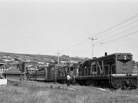 
A special place – The Rock. 
<br>
<br>
Two trains in one: Terra Transport train #231 - Tuesday, Thursday, Saturday - has spotted the CN box bar and lifted the CP box car at Carbonear station,
<br>
<br>
 TT #232's crew is on lunch break prior to departure for St.John's: powered by GMD G8's TT #805 - TT #800. 
<br>
<br>
Carbonear Freight Shed on the extreme left. 
<br>
<br>
...no other place like it.....
<br>
<br>
August 7, 1982 negative by S.Danko.
<br>
<br>
More Terra Transport:
<br>
<br>
 <a href="http://www.railpictures.ca/?attachment_id=7438"> Terra Transport #232 near Clarke's Beach </a> 
<br>
<br>
   <a href="http://www.railpictures.ca/?attachment_id=6808"> Terra Transport #206 near Lockston </a> 
<br>
<br>
   <a href="http://www.railpictures.ca/?attachment_id=6608"> Terra Transport power for #204, Port-aux-Basques </a> 
<br>
<br>
   <a href="http://www.railpictures.ca/?attachment_id=6220"> TT #927, Port-aux-Basques </a> 
<br>
<br>
  <a href="http://www.railpictures.ca/?attachment_id=6336"> TT #929, Corner Brook </a> 
<br>
<br>
sdfourty.
