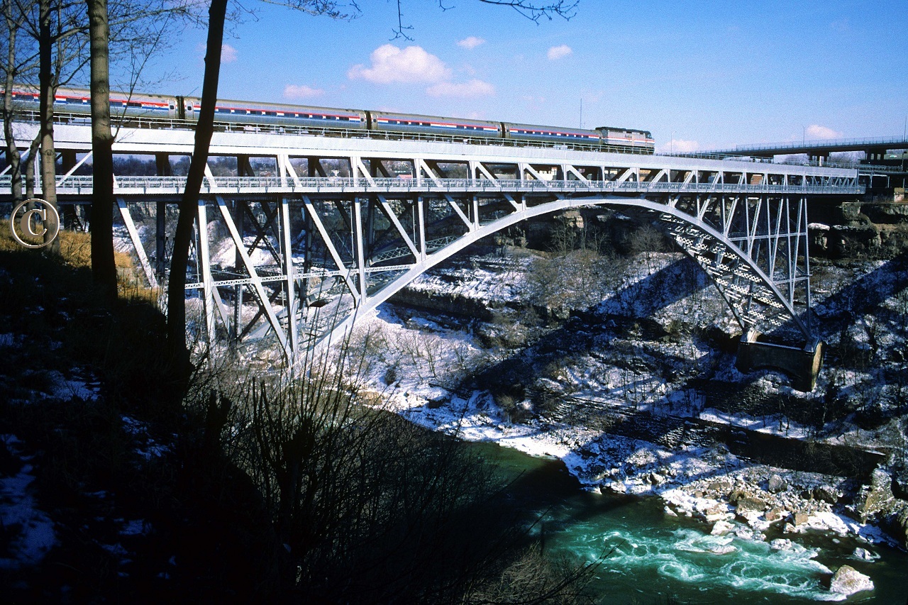 Amtrak 324 with Toronto to New York City train 97, The Maple Leaf, crosses high above the Niagara River on the Whirlpool Rapids Bridge.