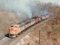 At a location which I refer to in my old notes as Bayview East, (now 'Snake') the power for CN #392 smokes it up en route to its transfer down to Burlington West where it parked in behind the station in the former industrial yard awaiting further assignment.  The photo is shot from Plains Rd West bridge at a location close to where old Hwy 6 and Hwy 2 used to come togther under the junction name of Wolfe Island, which can be seen engraved in the new replacement concrete structure at the entrance to the railfans' Walk Bridge.  Poweer swirling under clouds of white exhaust are: CN 9172, 9195, 9175, 2513, 5190 and 9518. My assumption is the last four units ran light into Hamilton to pick up the A-B-A and the consist of #392 is tucked away at Aldershot yard. Or was this a Fort Erie to Toronto train? Anyone??